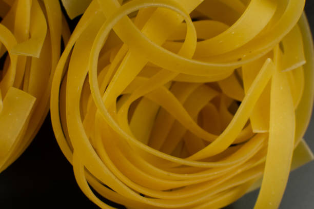 raw italian tagliatelle Pasta on dark background