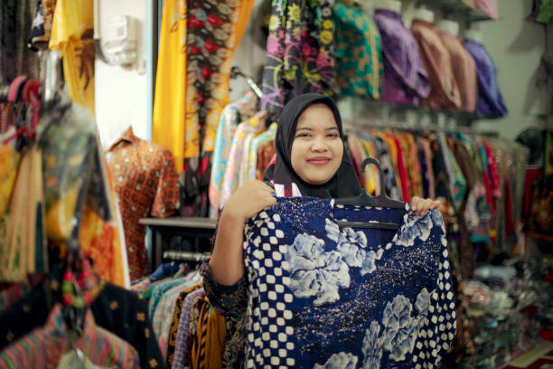 hora de compras. mulher nova na compra no mercado tradicional no centro do batik em java central, indonésia - etnia indonésia - fotografias e filmes do acervo