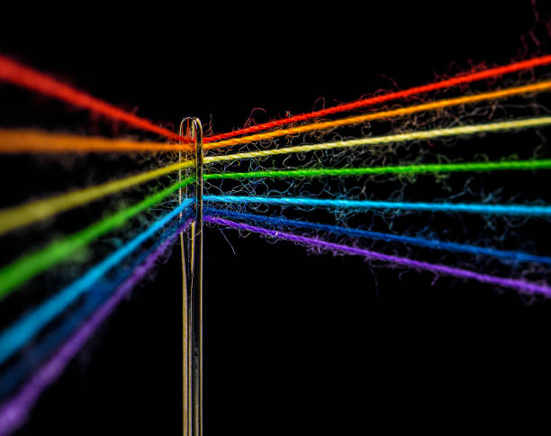 istock Colored threads are threaded through the eye of the needle 1196303647