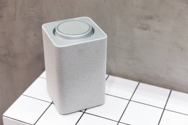 a gray bluetooth speaker, square, music column stands on a tile of white squares a gray, square, music column stands on a tile of white squares dubstep photos stock pictures, royalty-free photos & images