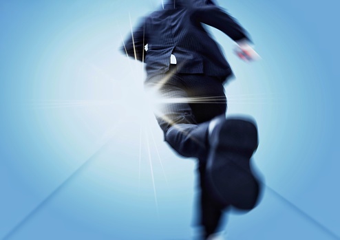 Back view of a businessman running towards a goal