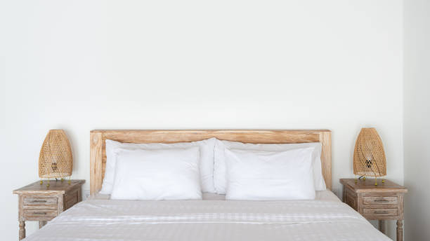 istock Cozy bed with wicker night lamp on bedside table at modern house interior 1196307631