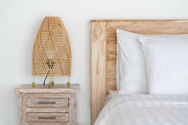 istock Cozy bed with wicker night lamp on bedside table at modern house interior 1196307645