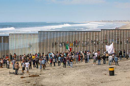 Tijuana, Mexico, March 29 - Migrants and workers gather on both sides of the iron and steel wall that separates the border between Mexico and the United States in Playas de Tijuana.