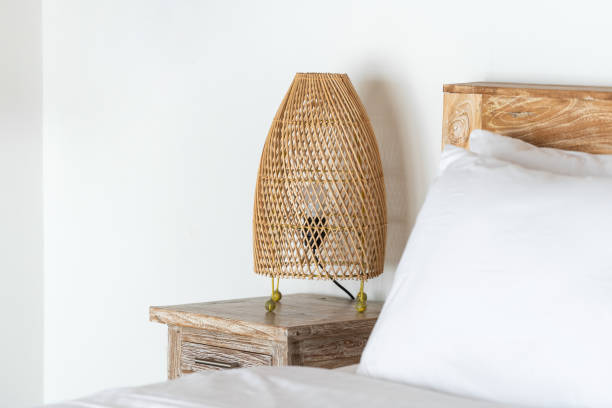 istock Cozy bed with wicker night lamp on bedside table at modern house interior 1196308285