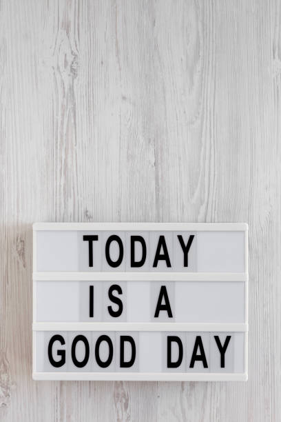 istock 'Today is a good day' words on a lightbox on a white wooden background, top view. Overhead, from above, flat lay. Copy space. 1196317981