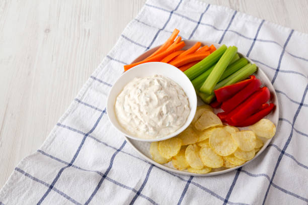 istock Homemade Caramelized Onion Dip with Potato Chips, Celery, Pepper and Carrot on cloth, low angle view. Copy space. 1196318683