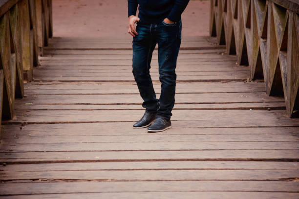 Man in blue jeans standing on a wooden surface unique stock photo