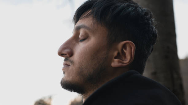 istock Handsome brunette turkish man relaxes in nature, taking a deep breath. Relaxation concept. 1196328224