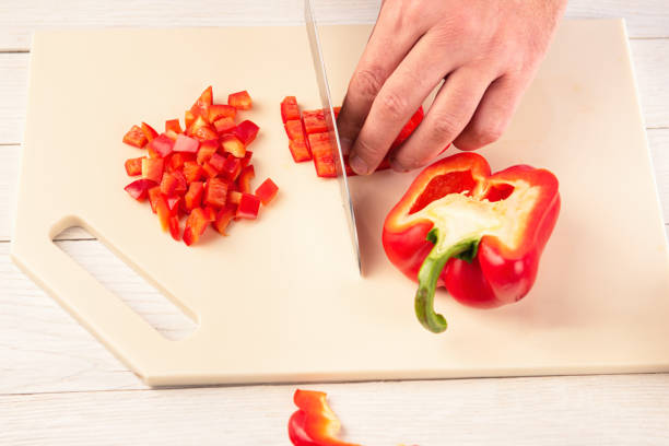 istock A section of bell pepper with a sharp knife on a cutting board made of artificial stone 1196330380