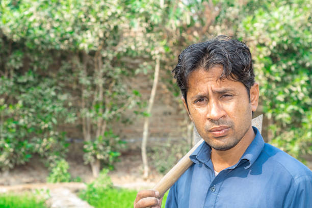 an asian farmer is working at fields and wearing blue uniform