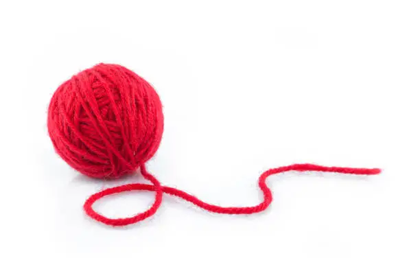 Photo of yarn color red on white background.