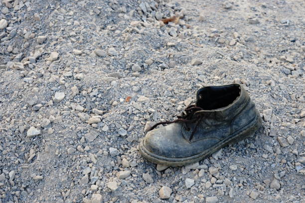 istock Old pair of shoes on sand 1196336604