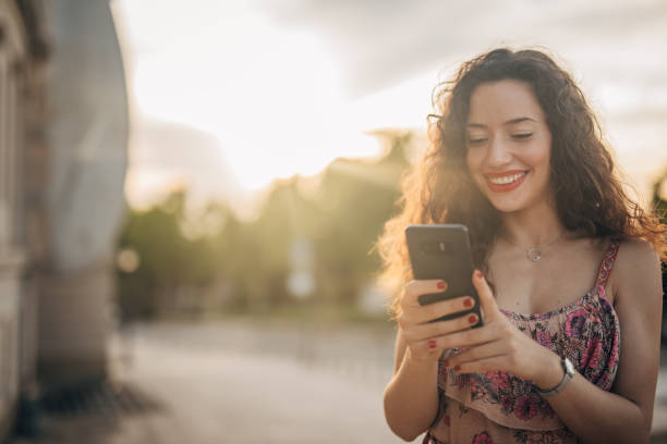 istock Beautiful Spanish lady using mobile outdoors 1196338390