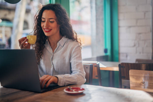 istock Beautiful lady using laptop in cafe 1196338941