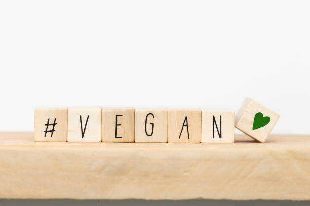 cubos de madera con un hashtag y la palabra vegana, fondo conceptual de las redes sociales - healthy eating red colors healthcare and medicine fotografías e imágenes de stock