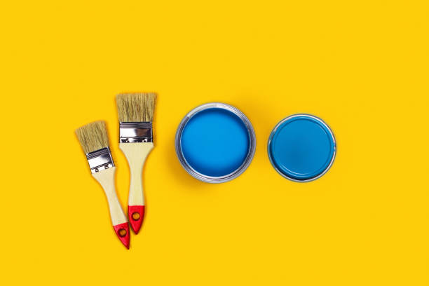 istock Colored background with paint jar and brushes. 1196341338