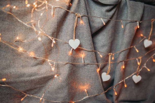 biglietto di san valentino. cuori di legno bianco sullo sfondo grigio. cuori con luci di ghirlanda e materia grigia sullo sfondo. - gray matter foto e immagini stock