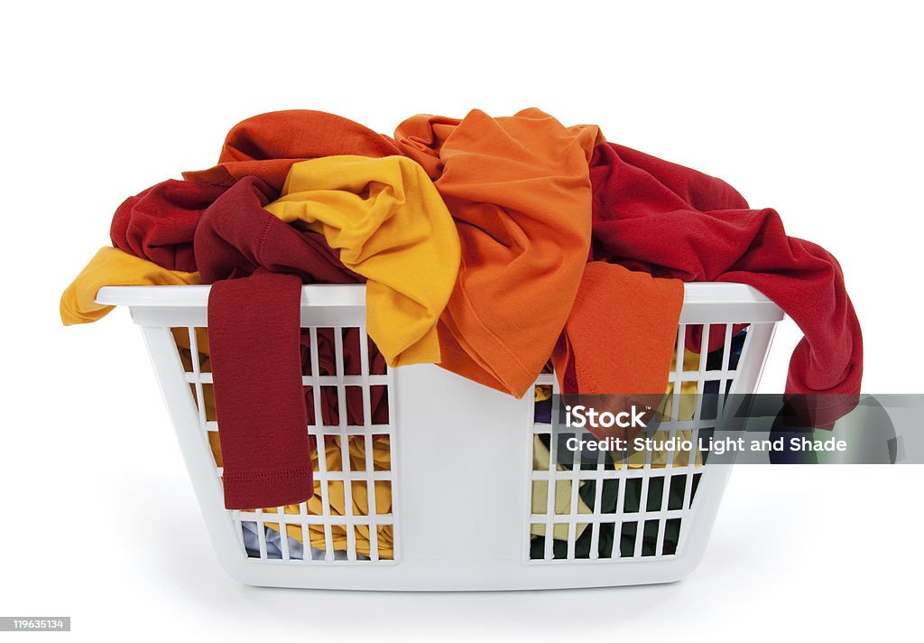 Roupas coloridas em cesta de lavanderia. Vermelho, laranja, amarelas. - Foto de stock de Algodão - Material Têxtil royalty-free