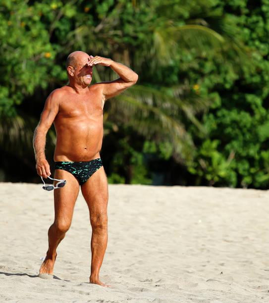 homem sênior saudável que olha para fora ao mar - calções de corrida - fotografias e filmes do acervo