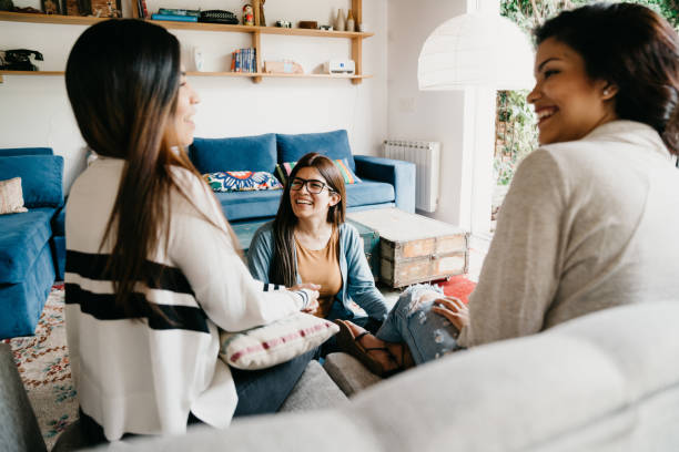 istock Three friends talking together at home 1196352199