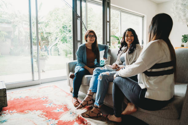 istock Three friends talking together at home 1196352202