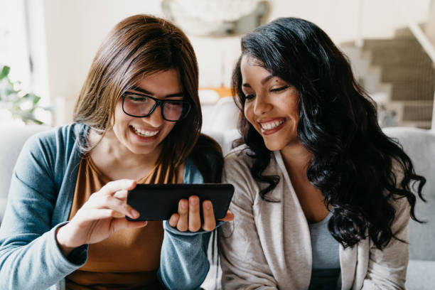 istock Two friends looking a smartphone together 1196352215
