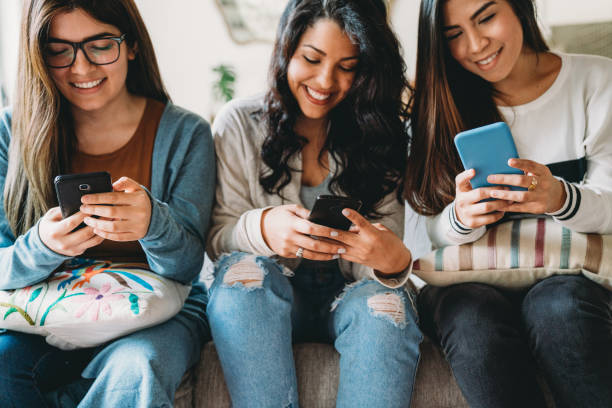 istock Three friends using mobile phones together at home 1196352228