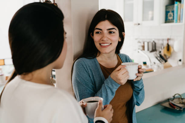 istock Two young adult women talking together while drinking coffee 1196352239