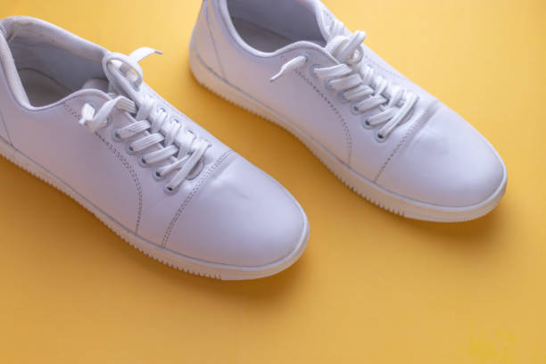 istock White sneakers on light colour background, flat lay top view minimal background. 1196354213