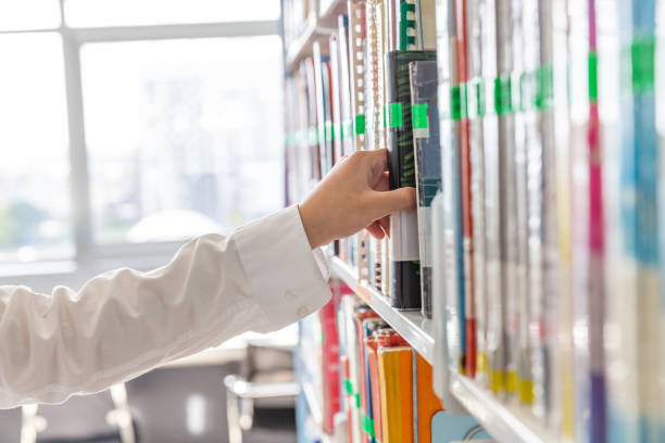 istock Stack of books put on bookshelf near window.Education  concept for knowledge. 1196355790
