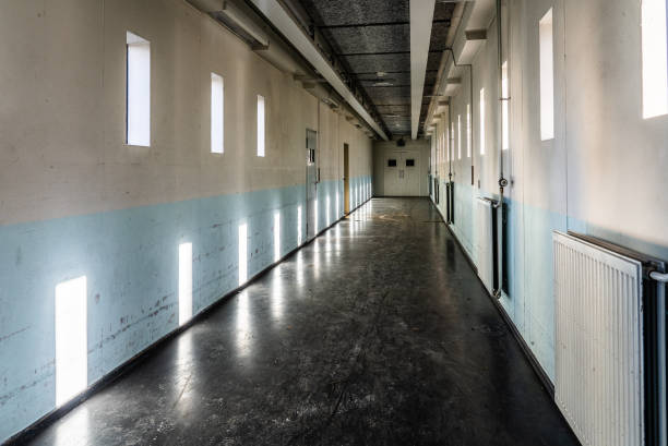 istock A long bare corridor with light and dark shadow spots. The corridor evokes an unpleasant and anxious feeling 1196356172