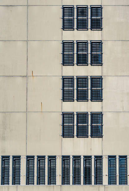istock The concrete facade of a prison. The windows are fitted with bars so that the prisoners cannot escape. The windows are placed symmetrically in the facade 1196356183