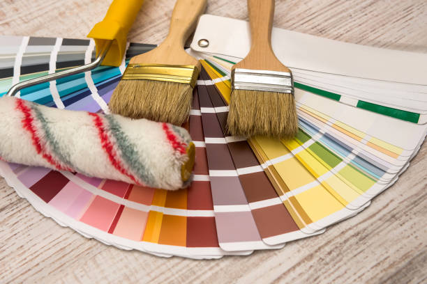 istock Color palette guide and paint brush roller  on wood board. 1196364116