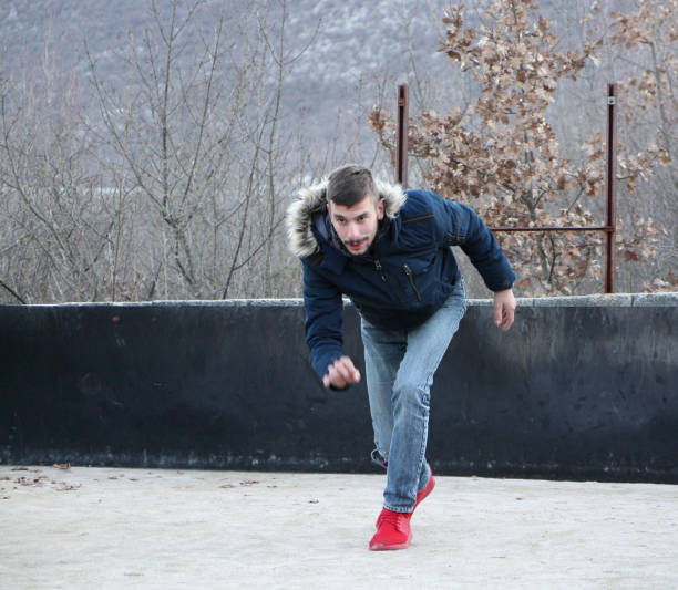 istock Handsome young man playing boccie game outside 1196364282