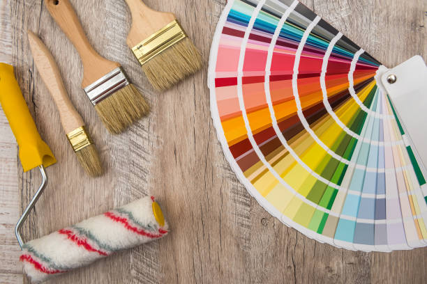 istock Color palette guide and paint brush roller  on wood board. 1196364400