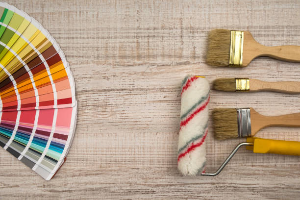 istock Color palette guide and paint brush roller  on wood board. 1196365280