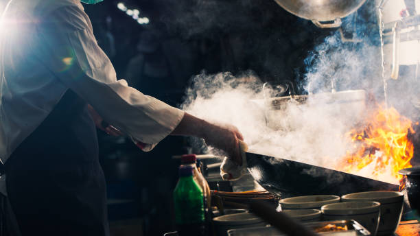 istock Chef stir fry in wok 1196370430