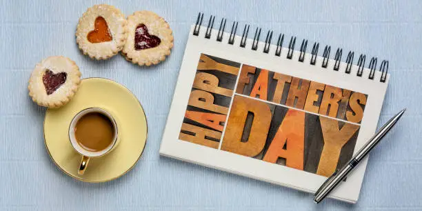 happy father's day greeting card - a word abstract in vintage wood letterpress printing blocks in a sketchbook with coffee and heart cookies