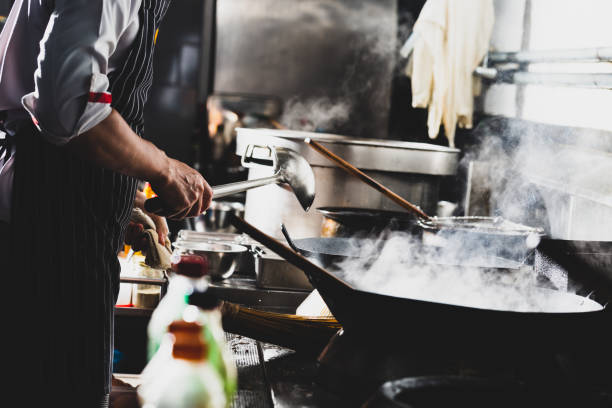 istock Chef stir fry in wok 1196372375