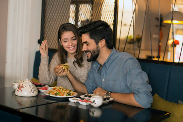 istock Smiling couple eating noodles 1196373380