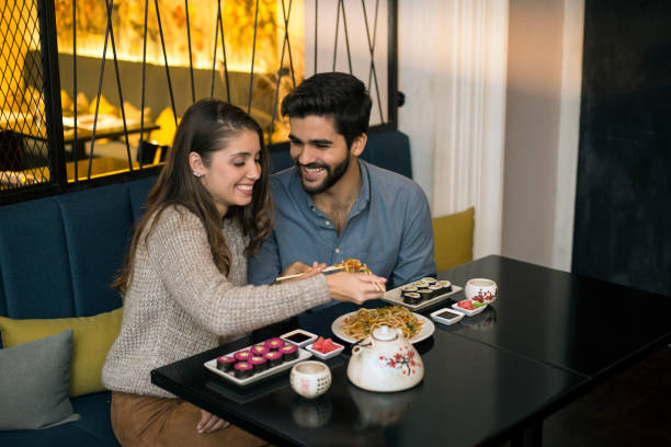 istock Happy young couple eating noodles 1196373988
