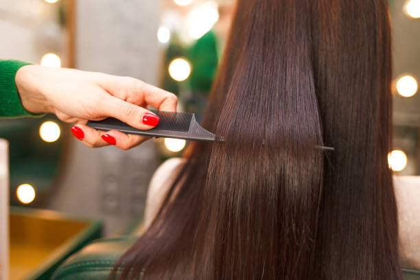 capelli lisci e lucenti dopo la laminazione. parrucchiere dimostra il risultato della raddrizzatura dei capelli di cheratina - sistemare foto e immagini stock