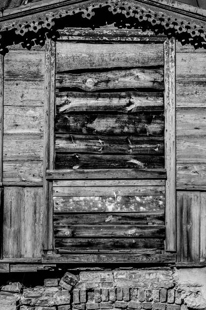 Monochrome image of door of abandoned old wooden house hammered with planks