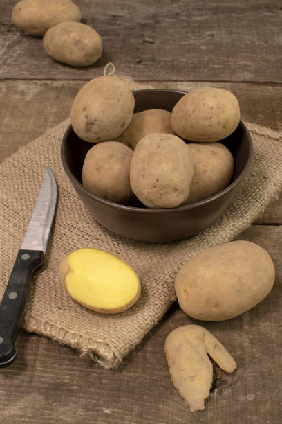 istock Peeled potatoes on the wooden table 1196375204