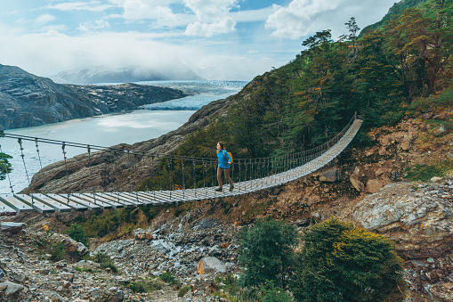 Young Caucasian woman looking at Grey glacier in Torres del Paine National Park