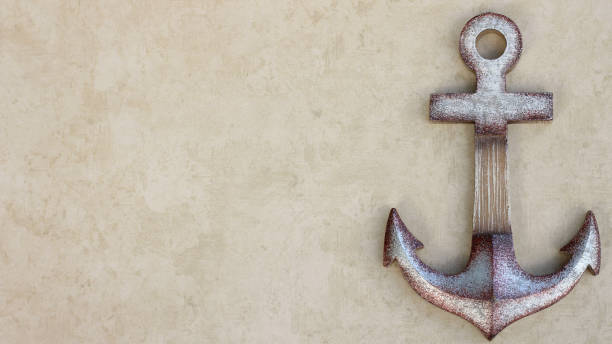istock ship anchor isolated on a tan background with writing space 1196383153