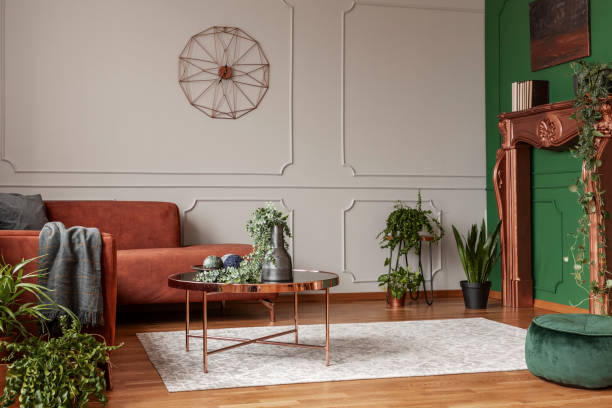 elegante tavolino color rame di fronte al comodo divano ad angolo nel soggiorno alla moda - fireplace living room door wall foto e immagini stock