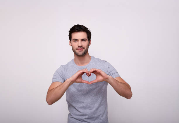 istock A handsome white man made a heart with his hands. 1196384467