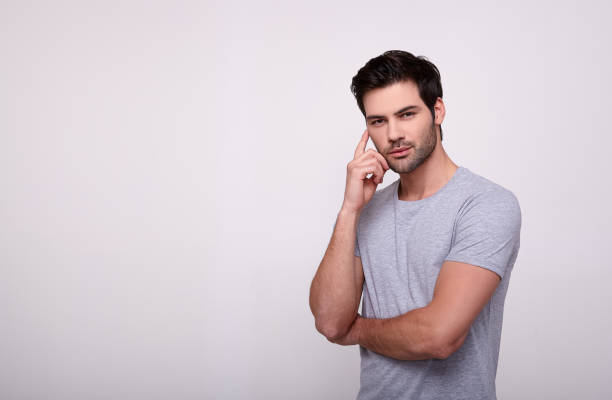 istock A young serious guy with a beard on a gray background. 1196385257